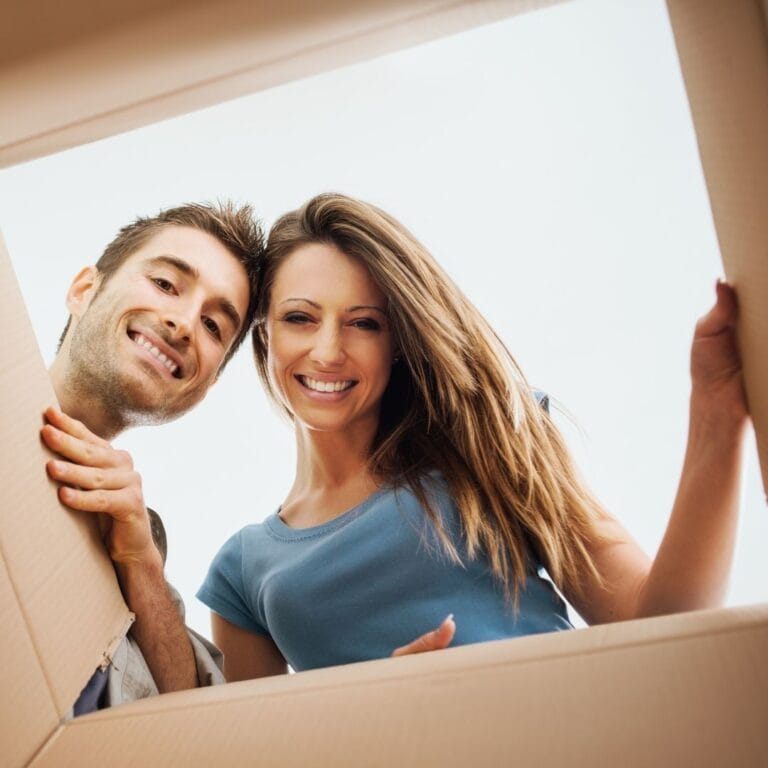 smiling couple looking down in box