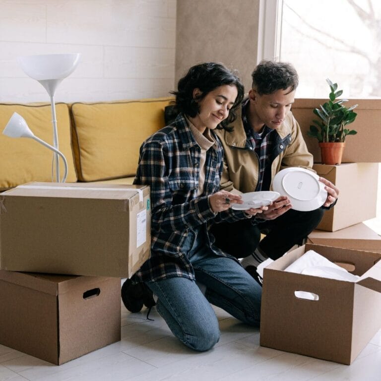 couple unpacking moving boxes in living room